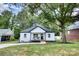 Charming white brick home with a cozy front porch, surrounded by lush greenery at 141 Ole Eastpointe Dr, York, SC 29745