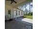 The covered back patio with a ceiling fan offers a space to relax in the shade at 142 Highland Dr, New London, NC 28127