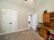Cozy bedroom featuring neutral carpets, built-in shelving, and a view into an adjoining room, enhancing the living space at 142 Highland Dr, New London, NC 28127