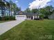 Single-story home with an attached garage, well-manicured lawn, and concrete driveway at 142 Highland Dr, New London, NC 28127