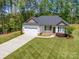 Exterior elevation of a home featuring a two-car garage, well-maintained lawn, and inviting front entrance at 142 Highland Dr, New London, NC 28127