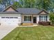 Charming single-story home featuring a manicured lawn and a two-car garage at 142 Highland Dr, New London, NC 28127