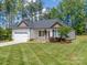 Charming exterior of a well-maintained single-story home with an attached two-car garage at 142 Highland Dr, New London, NC 28127