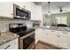 Bright kitchen with stainless steel appliances, granite counters, white cabinets, and tile backsplash, perfect for modern cooking at 142 Highland Dr, New London, NC 28127