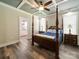 Bedroom featuring a four-poster bed, tray ceilings, and ensuite bathroom access at 142 Highland Dr, New London, NC 28127