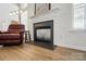 Close-up of the living room fireplace with an adjacent leather armchair at 146 Burtons Barn Rd, Mooresville, NC 28115