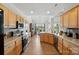 A bright kitchen with wooden cabinets, stainless steel appliances, and an eat-in dining area with views of the backyard at 146 Burtons Barn Rd, Mooresville, NC 28115