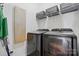 A modern laundry room featuring Samsung washer and dryer, a storage shelf with baskets and a light-wood utility board at 146 Burtons Barn Rd, Mooresville, NC 28115