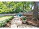 Landscaped backyard featuring a stone walkway, a seating area, and beautiful plantings at 206 Pelham Ln, Fort Mill, SC 29715