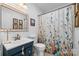 Bathroom with floral shower curtain, a blue vanity and decorative mirror at 206 Pelham Ln, Fort Mill, SC 29715