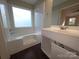This bathroom features a shower-tub combo, single sink vanity, and dark floor at 2105 Killarney Pl, Charlotte, NC 28262