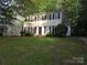 Charming two-story home featuring a classic colonial design, surrounded by lush greenery and mature trees at 2105 Killarney Pl, Charlotte, NC 28262