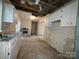 Kitchen with missing ceiling and exposed wiring, and damaged flooring, offering a full renovation opportunity at 2105 Killarney Pl, Charlotte, NC 28262