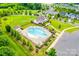 Aerial view of community pool and clubhouse with lounge chairs, lush landscaping, and parking at 217 Barberry Dr, Belmont, NC 28012