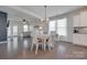 Open dining area with modern chandelier lighting, wood floors, and access to the living room at 217 Barberry Dr, Belmont, NC 28012