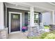 Inviting front porch with stone pillars, rocking chairs, and a stylish front door at 217 Barberry Dr, Belmont, NC 28012