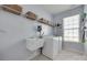 Functional laundry room with a utility sink, washer, dryer, and ample storage shelves at 217 Barberry Dr, Belmont, NC 28012