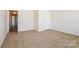 A bright bedroom with neutral carpet and walls, with a door to the hallway at 2327 Glenway Trail Ct, Pineville, NC 28134