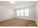 Bright bedroom with neutral carpet and walls, and abundant light from the double window at 2327 Glenway Trail Ct, Pineville, NC 28134