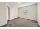 Bright bedroom with plush carpeting, a window, and a view into the hallway at 2327 Glenway Trail Ct, Pineville, NC 28134