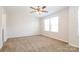 A bright bedroom features neutral walls and carpet, a ceiling fan and a double window allowing abundant light at 2327 Glenway Trail Ct, Pineville, NC 28134