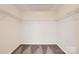 A well-organized walk-in closet with neutral walls and carpet, and white shelving at 2327 Glenway Trail Ct, Pineville, NC 28134