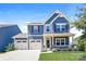 Charming two-story blue home features a manicured lawn, a two car garage, and covered porch at 2327 Glenway Trail Ct, Pineville, NC 28134