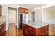 Kitchen with cherry cabinets, a large island, stainless steel appliances, and light-filled dining area at 2327 Glenway Trail Ct, Pineville, NC 28134