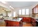Virtual staged kitchen features an island with granite counters, wood cabinets and stainless steel appliances at 2327 Glenway Trail Ct, Pineville, NC 28134