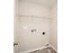 An empty laundry room with gray walls, tile floor and metal shelf for storage at 2327 Glenway Trail Ct, Pineville, NC 28134