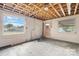 Unfinished basement is equipped with a window, door, and exposed wooden ceiling rafters at 2336 32Nd Ne St, Hickory, NC 28601
