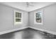 This bedroom features light gray walls, black-painted hardwood floors, and two windows with a view of the outdoors at 2336 32Nd Ne St, Hickory, NC 28601