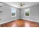 This bedroom features light gray walls, hardwood floors, a ceiling fan, and two windows with a view of the outdoors at 2336 32Nd Ne St, Hickory, NC 28601
