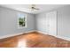 This bedroom features light gray walls, hardwood floors, a ceiling fan, and a window with a view of the outdoors at 2336 32Nd Ne St, Hickory, NC 28601