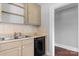 Functional kitchen featuring tan cabinets, stainless steel sink, dishwasher and access to additional space at 2336 32Nd Ne St, Hickory, NC 28601