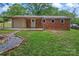 Backyard featuring an open patio with exposed brick, privacy border, and lush green grass at 2401 Woodleaf Dr, Gastonia, NC 28052