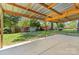 Covered patio with concrete base offers outdoor living space, with yard, shed, and gravel parking area at 2401 Woodleaf Dr, Gastonia, NC 28052