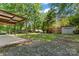 The backyard has a covered patio, wooden shed, and a small fire pit at 2401 Woodleaf Dr, Gastonia, NC 28052