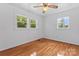 Bright bedroom featuring hardwood floors, ceiling fan, and dual windows for enhanced natural light at 2401 Woodleaf Dr, Gastonia, NC 28052