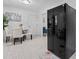 View of the dining area with a black refrigerator, white plank flooring and decor creating a welcoming space at 2401 Woodleaf Dr, Gastonia, NC 28052