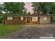 Charming brick home with traditional shutters and inviting front entrance, with landscaped yard and mature trees at 2401 Woodleaf Dr, Gastonia, NC 28052
