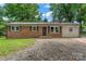 Charming brick home featuring a chimney, dark shutters, and inviting front entrance at 2401 Woodleaf Dr, Gastonia, NC 28052