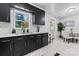Well-lit kitchen with black cabinets, quartz countertops, modern fixtures, and a view to the outside at 2401 Woodleaf Dr, Gastonia, NC 28052