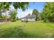 A grassy backyard with the rear of the house and mature trees at 304 Miller Ave, Salisbury, NC 28144