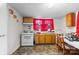 Eat-in kitchen featuring classic appliances, a table with seating and bright red curtains at 304 Miller Ave, Salisbury, NC 28144