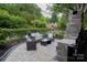 Landscaped backyard with stone patio, outdoor fireplace, and comfortable seating at 324 N 5Th St, Albemarle, NC 28001