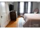 Comfortable bedroom with a mounted TV, wooden dresser and ample natural light from a bright window at 324 N 5Th St, Albemarle, NC 28001