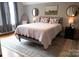 Cozy bedroom featuring floral pillows, decorative mirrors, and a striped quilt on a comfortable bed at 324 N 5Th St, Albemarle, NC 28001
