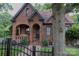 Charming brick home featuring an arched porch, black trim, and a well-maintained front yard with mature tree at 324 N 5Th St, Albemarle, NC 28001