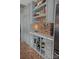 Close up of the kitchen with shaker cabinets, wine racks, and an exposed brick element at 324 N 5Th St, Albemarle, NC 28001